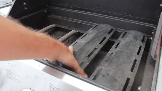 Grill heat shield cleaning